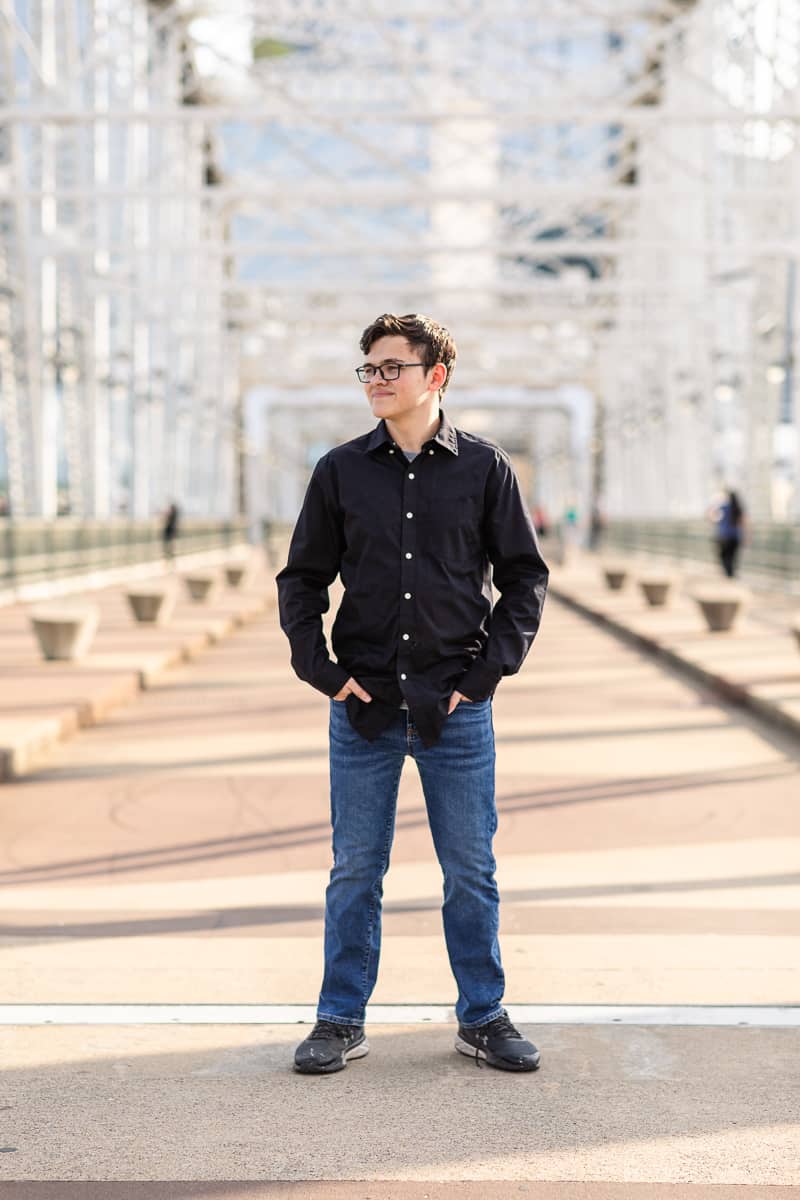 senior boy standing on bridge in Nashville
